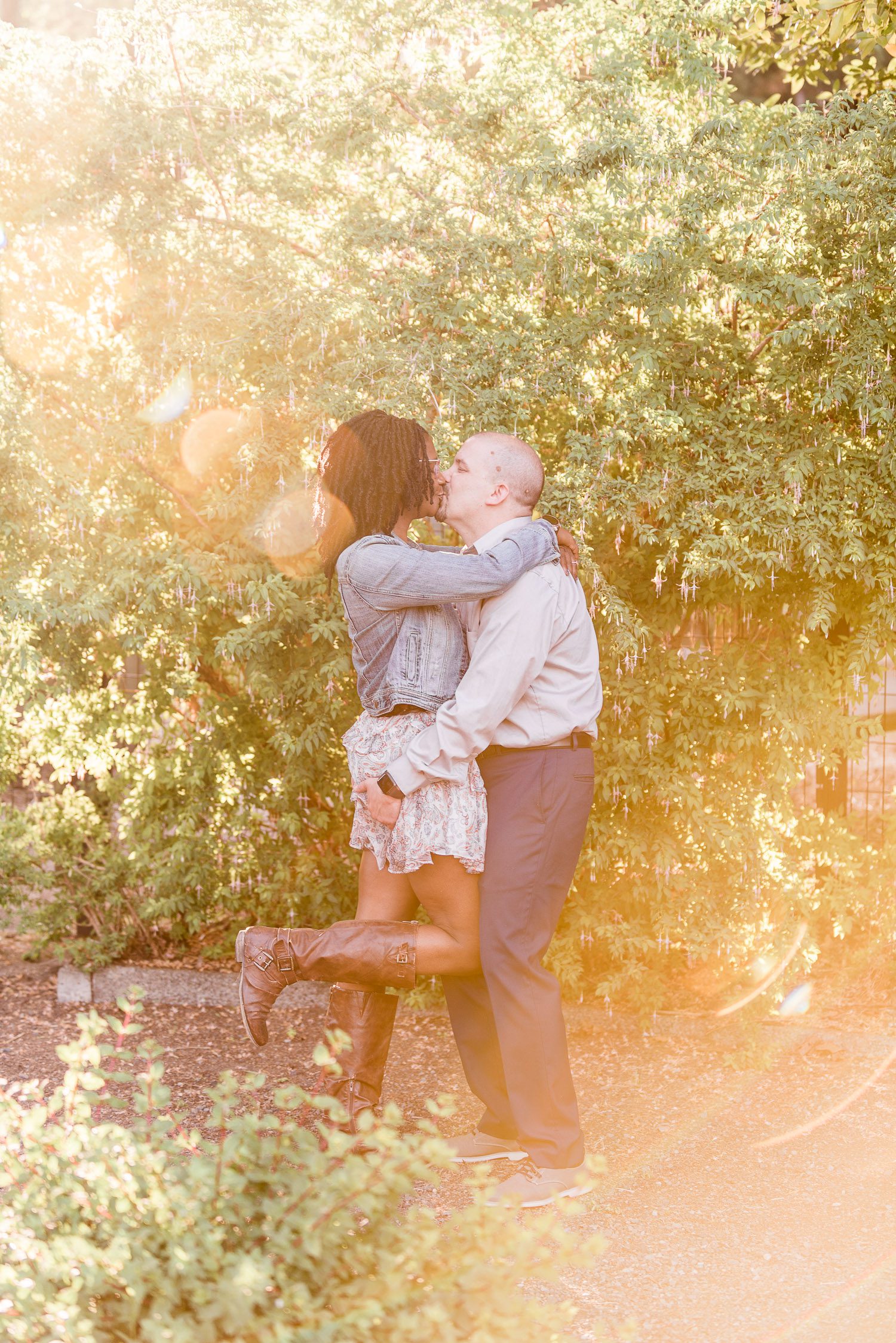 Interracial Couple kissing each other under the golden sun during their engagement session in Tacoma, Washington.